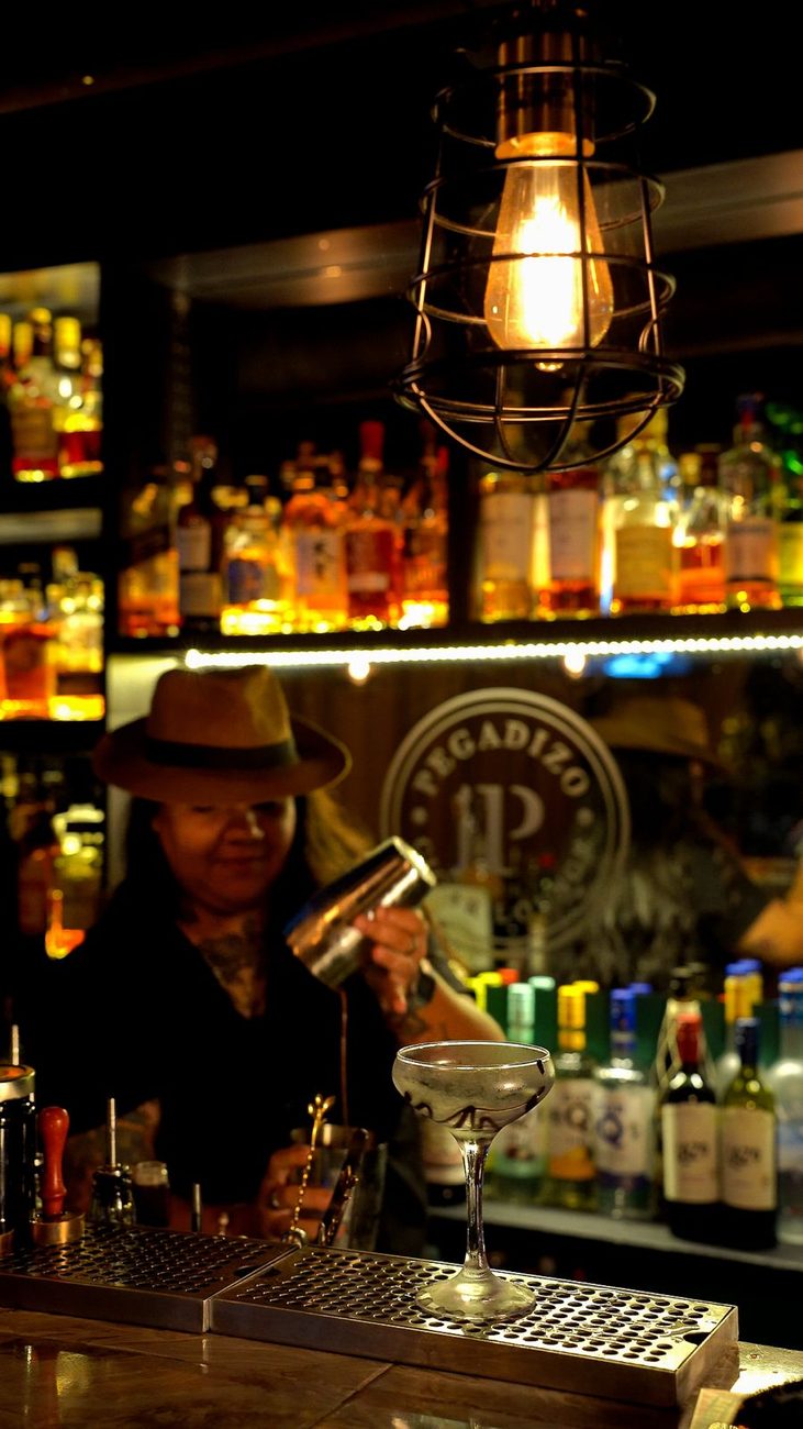 La barra de noche, con las botellas y la lampara colgante