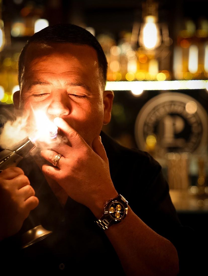 Encendiendo un cigarro, la llama iluminando la cara