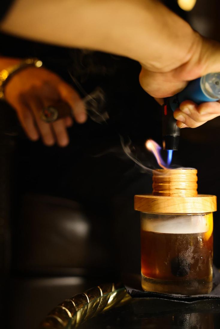 Un soplete encendiendo un trago ahumado