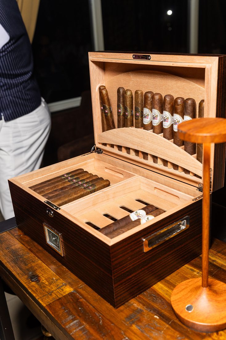 El humidor de cigarros Pegadizo abierto sobre la mesa de madera