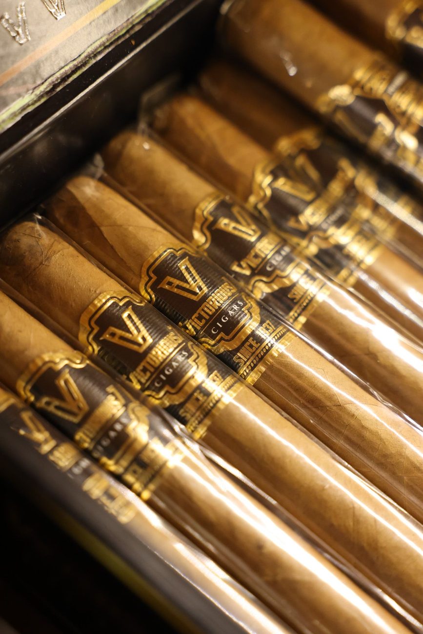 Cigarros alineados en el humidor, con las vitolas doradas